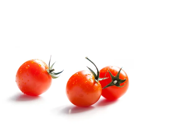 Tres tomates cherry sobre un fondo blanco —  Fotos de Stock