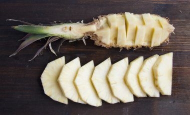Tahta arka planda dilimlenmiş ananas.