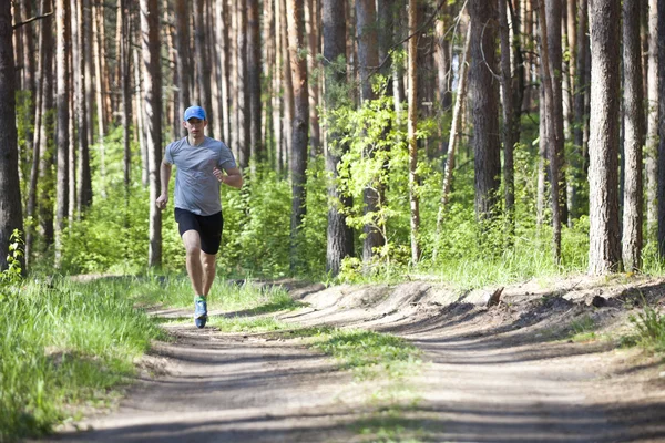 Um jovem correndo na floresta — Fotografia de Stock