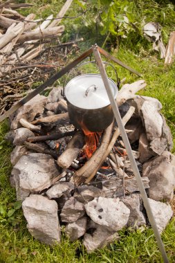 Pot bir tripod üzerinde asılı yanıyor