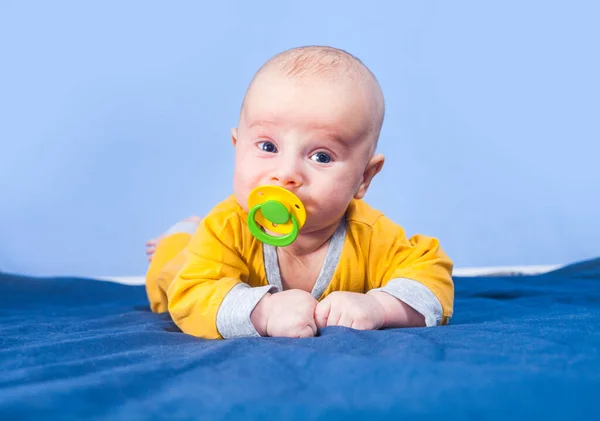 Tre Månader Baby Pojke Med Napp Ligger Magen Blå Bakgrund — Stockfoto