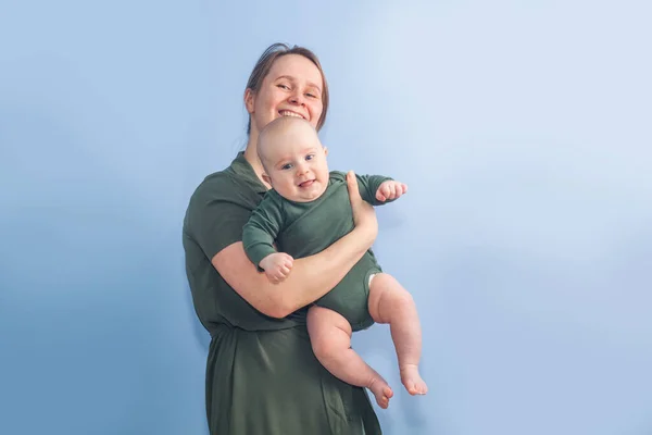 Bebé Cinco Meses Brazos Madre Sobre Fondo Pared Azul —  Fotos de Stock