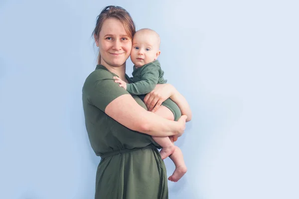 Fem Månader Baby Mammas Armar Blå Vägg Bakgrund — Stockfoto