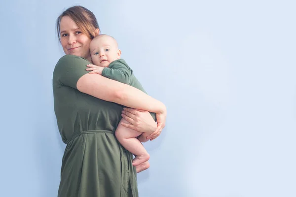 Bambino Cinque Mesi Tra Braccia Della Madre Sfondo Blu Parete — Foto Stock