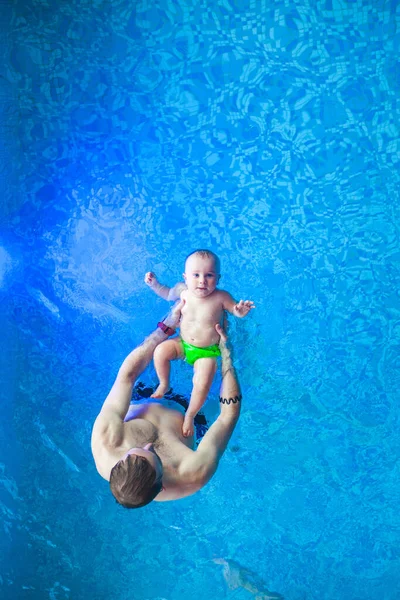 父亲和一个孩子在游泳池里婴儿在水里游泳 — 图库照片