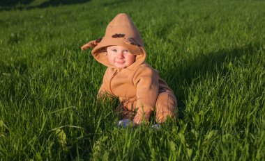 Yeşil çayırlarda oturan bebek.