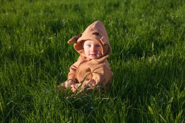 Yeşil çayırlarda oturan bebek.