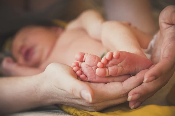 Baby nohy v rukou matky — Stock fotografie