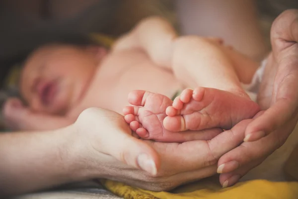 Baby fötter i mors händer — Stockfoto