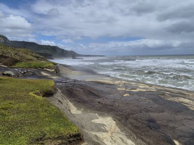 Güney Adası 'nın engebeli kıyı şeridinde dramatik uçurumlar ve Tasman Denizi var..