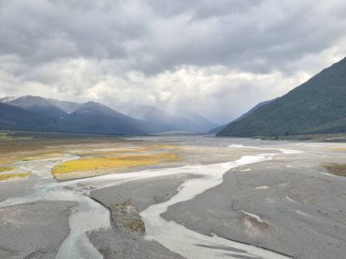 Waimakariri Nehri 'nin, Arthur Geçidi Ulusal Parkı' ndaki geniş çakıllı bir yatağın içinden yükseltilmiş geniş açılı görüntüsü.