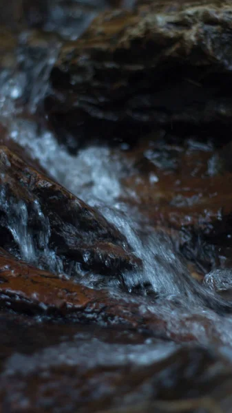 Close up of mountain river flows between picturesque summer stones. Rocks in the mountains with water flowing