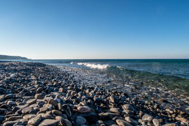 Kıyıda taşlarla ve küçük dalgalarla