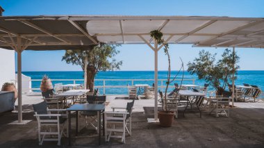 Girit, Keratokampos 'ta deniz kenarında açık bir restoranda rahat masalar ve sandalyeler