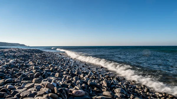 Seashore with stones and little waves