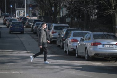 Iasi - Romanya - 13 Mart 2021: Karşıdan karşıya geçen adam