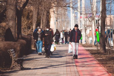 Iasi - Romanya - 13 Mart 2021: Öğleden sonra kaldırımda yürüyen insanlar