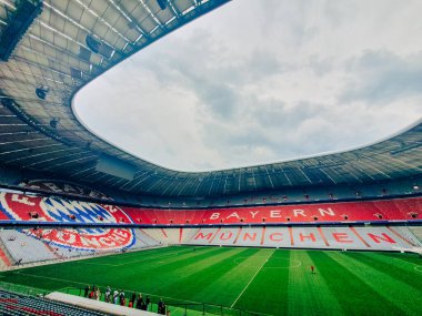 Münih, Almanya, 7 Ağustos 2024 - Allianz Arena 'nın içinde, Bayern Münih stadyumu, ikonik kırmızı ve beyaz koltuklu ve boş yeşil futbol sahası