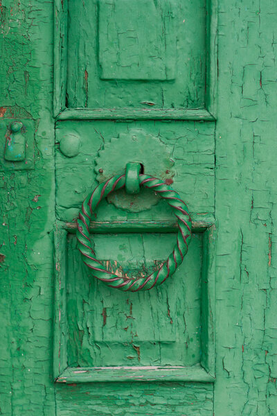 Старая зеленая дверь с круглой ручкой
