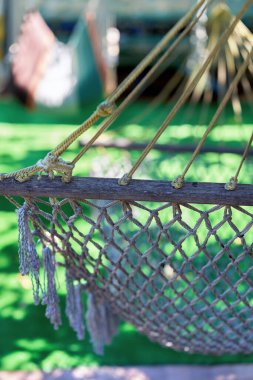 Halatlardan örülmüş bir hamak parçası ülkenin dinlenme bölgesinde asılı duruyor. Yakın çekim, dikey çekim