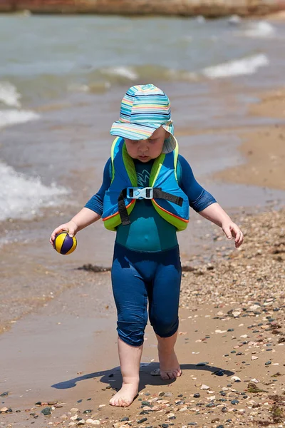 Bambino Giubbotto Una Palla Mano Cammina Lungo Acqua Lungo Spiaggia — Foto Stock