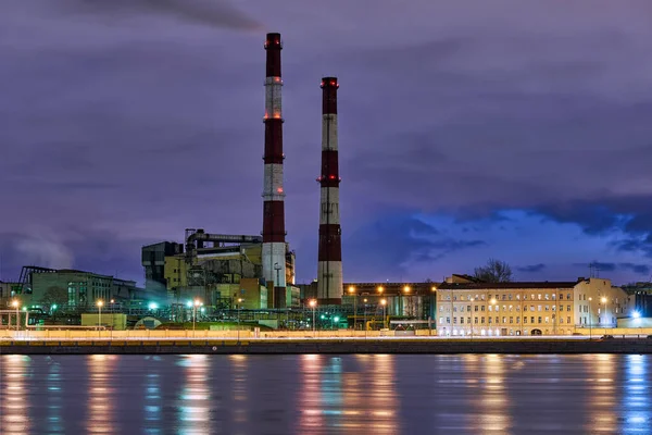 Neva Nehri 'nin Sinopskaya seti üzerindeki yüksek fabrika bacaları. Rusya, Saint Petersburg, gece kenti manzarası