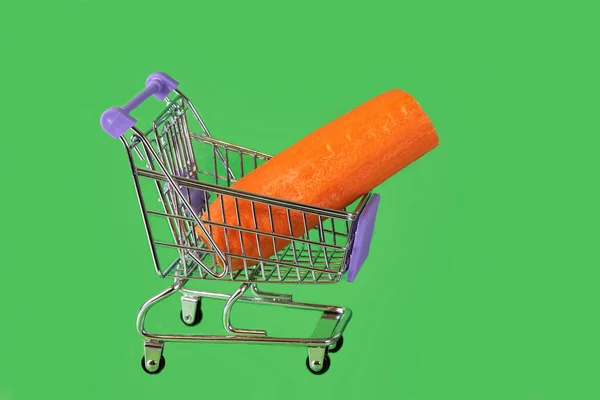 Oranje Geschilde Wortel Een Supermarkt Trolley Een Groene Achtergrond Close — Stockfoto