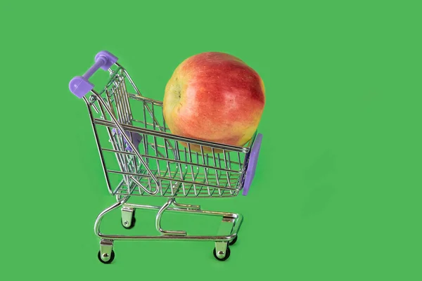 Verse Rode Appel Een Supermarkt Trolley Een Groene Achtergrond Close — Stockfoto