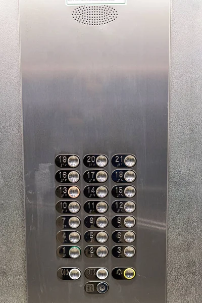 Shiny metal panel with round buttons with floor numbers