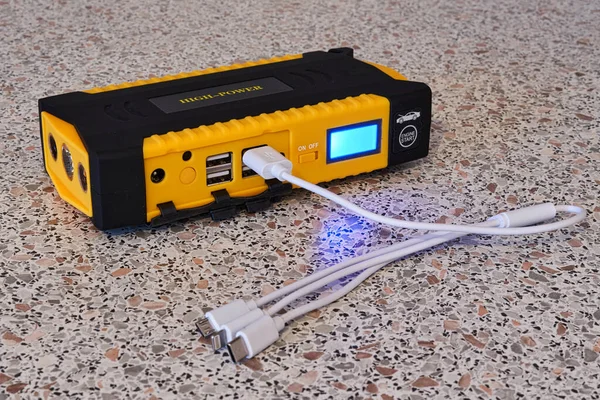 Banco de alimentación amarillo con un cable universal para diferentes tipos de carga — Foto de Stock