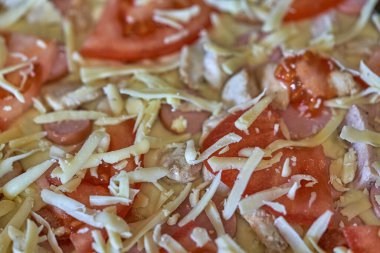 Domatesli, peynirli, zeytinli, arka planlı ve dokulu çiğ pizza.