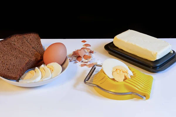 Zrobienie kanapki śniadaniowej, chleba i masła oraz jajka z cięciem jaj — Zdjęcie stockowe