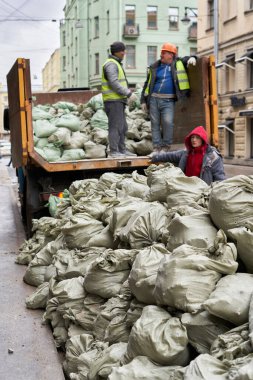 İşçiler inşaat atıklarını bir kamyona yüklüyorlar