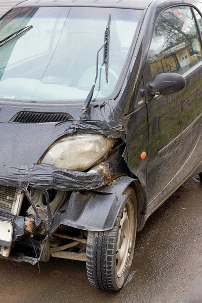 Fragmento de um carro pequeno com um pára-choques quebrado, um acidente na estrada — Fotografia de Stock