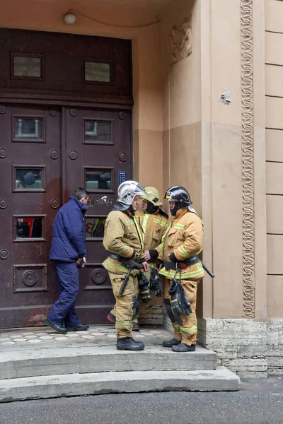 Bomberos de pie frente a una casa después de extinguir un incendio en Petersburgo — Foto de Stock