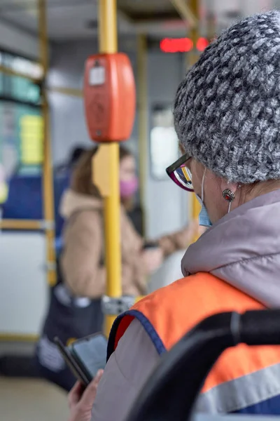 Turuncu yelekli bir kondüktör toplu taşıma üzerinde çalışır.