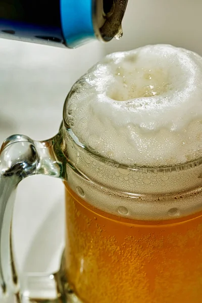La birra viene versata da una lattina in un calice di vetro trasparente — Foto Stock