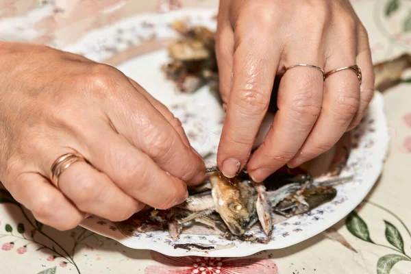 Руки розрізають смажену рибу, що відокремлює м'якоть від кісток — стокове фото