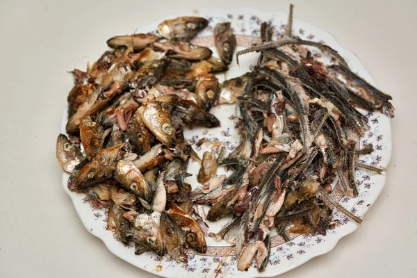 Têtes de poisson et os laissés après avoir mangé dans une assiette. — Photo