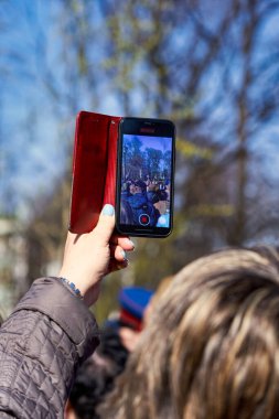 St. Petersburg, Rusya - 09 Mayıs 2021: Bir kadın Petersburg sokaklarında bir sokak müzisyeninin fotoğraflarını çekiyor