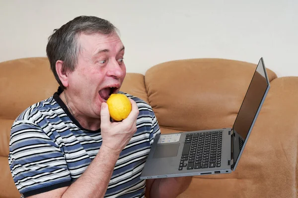 프리크는 소파에 노트북을 레몬을 먹는다 뉴스에서 나오는 감정들 — 스톡 사진