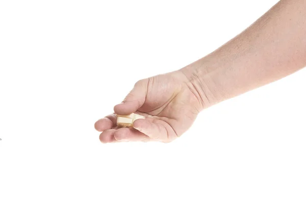 Hand holds a plastic dowel for screws on a white background — Stock Photo, Image