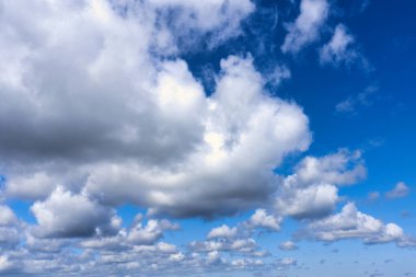 Mavi gökyüzü arka planında beyaz kümülüs bulutları, doğal fenomen