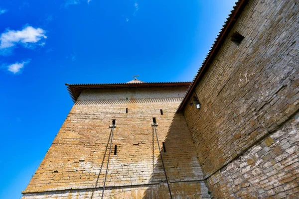 Fragmento de una pared fortaleza de ladrillo con una torre y cadenas de ascensor. — Foto de Stock