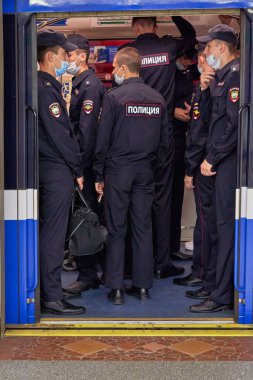 Bir grup polis metro vagonuna biniyor.