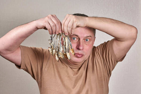 A man holds in his hands a lot of fish gnawed to the bone