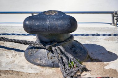 Bağlanmış bir halatla ya da demirleme halatıyla. Kapat.