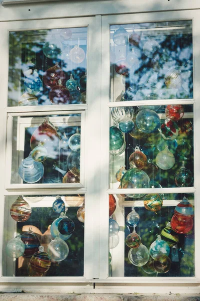 Multicolored glass balls in the window of a glass blowing workshop. Close up