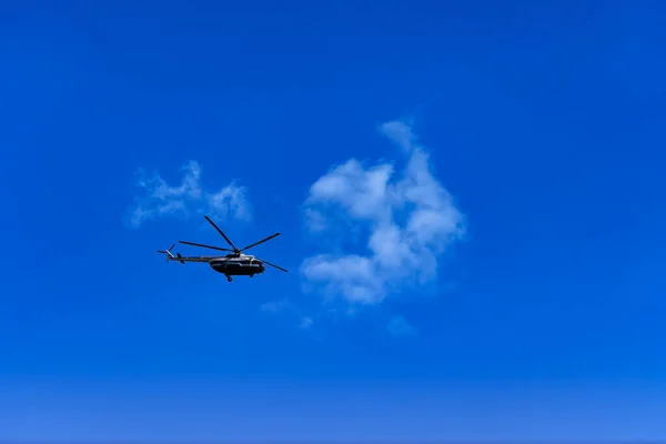 Flying helicopter on the background of clouds and blue sky — Stock Photo, Image