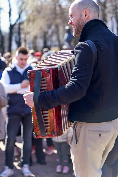 街头音乐家在圣彼得堡的城市居民面前弹奏手风琴 — 图库照片